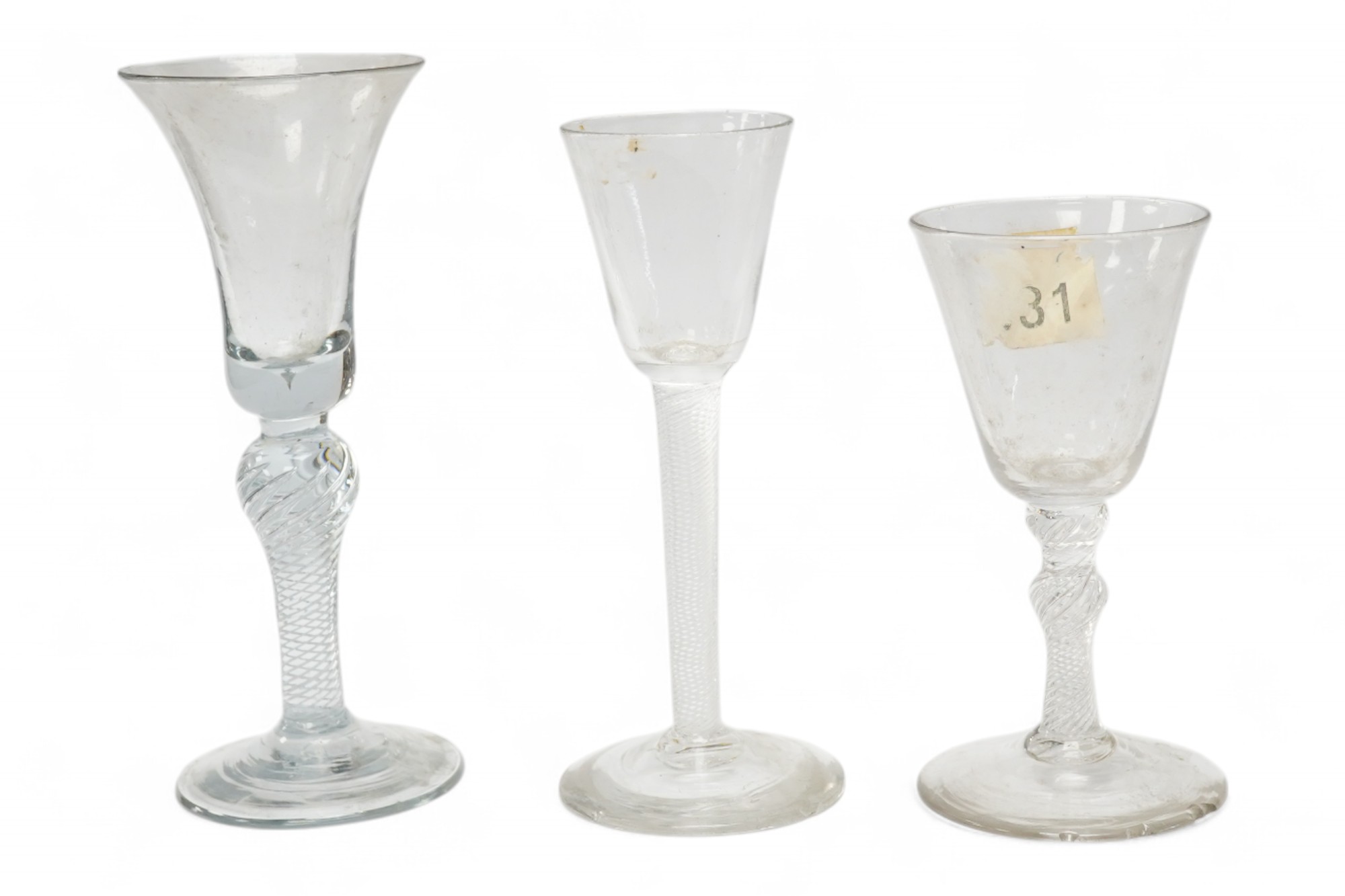 Three 18th century air twist stemmed wine glasses, tallest 16.5cm high. Condition - two having chips to edges of bases